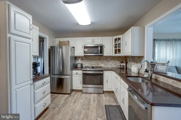 a kitchen with stainless steel appliances granite countertop a refrigerator stove and sink