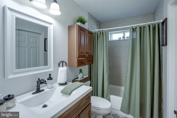 a bathroom with a sink vanity mirror and toilet