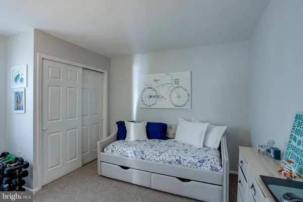 a bedroom with a bed and painting on the wall