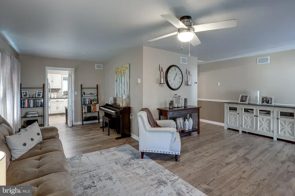 a living room with furniture a clock and wooden floor