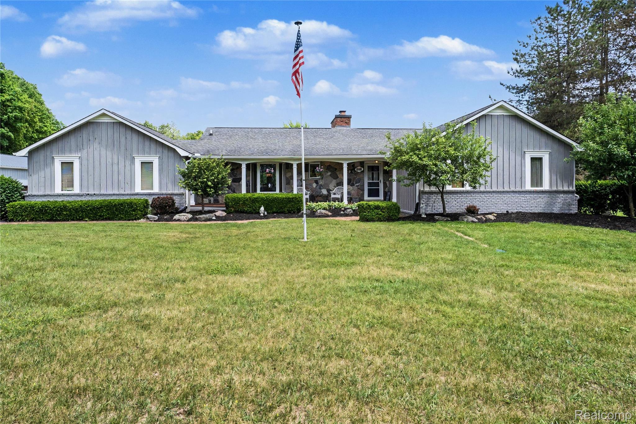 5465 South Lake George Road Metamora, MI 48455 - Photo 38 of 61 Ranch-style residence featuring a prominent stone facade, light gray vertical siding, and a dark shingle roof