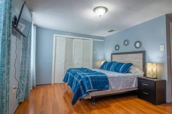 a bedroom with a bed and painting on the wall