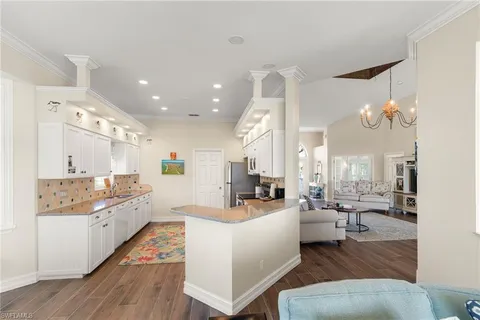 a large room with kitchen island a large window and a sink