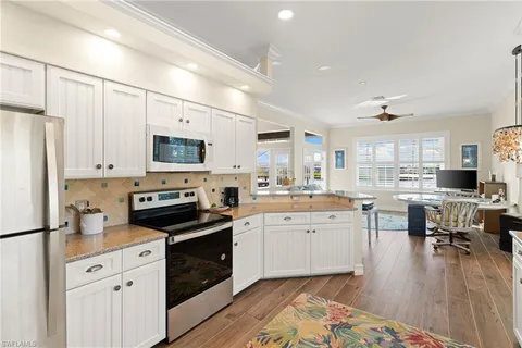 a kitchen with white cabinets and appliances