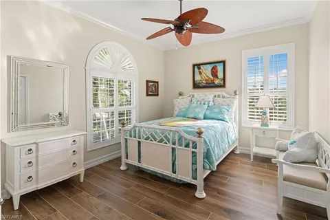 a bedroom with a large bed and wooden floor
