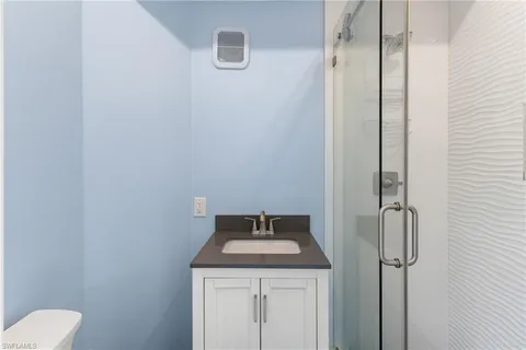 a bathroom with a granite countertop sink toilet and shower