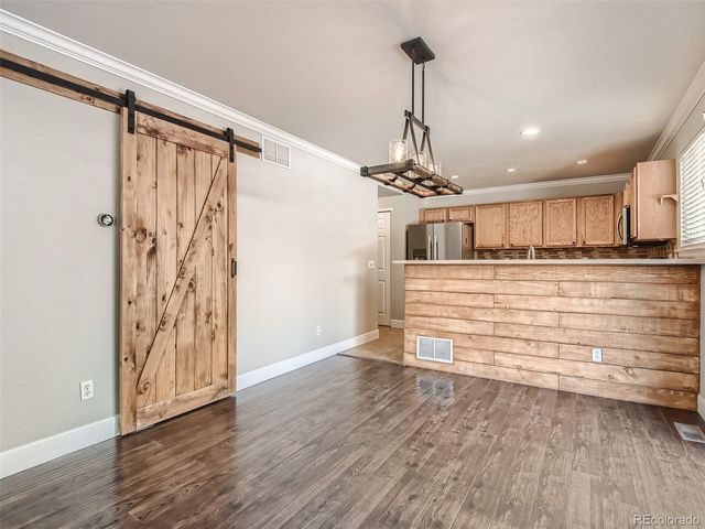 a view of a hallway with wooden floor and chandelier