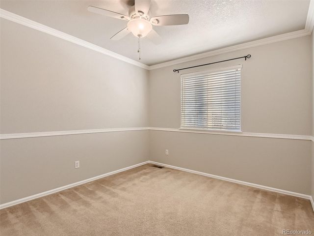 an empty room with a window and a fan