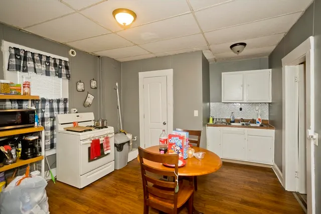 a kitchen that has a lot of white cabinets and wooden floor