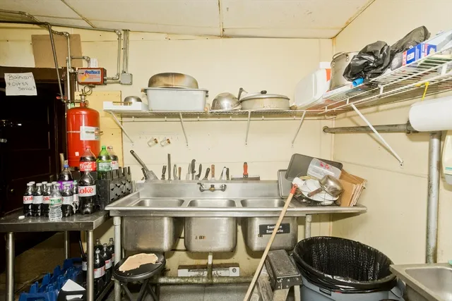 a kitchen with a sink and a stove with chairs