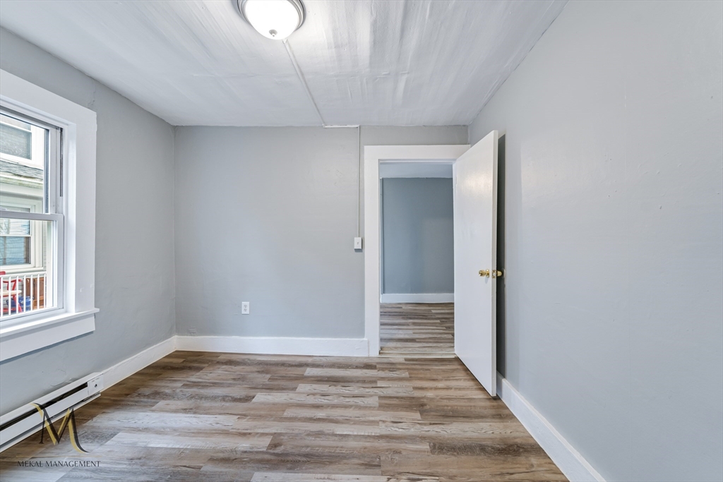 89-95 School Street Chicopee, MA 01013 - Photo 4 of 39 a view of an empty room with wooden floor and a window