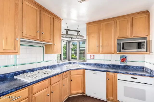 a kitchen with granite countertop cabinets stainless steel appliances a sink and a window