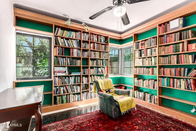 a reading room with furniture book shelf and a window
