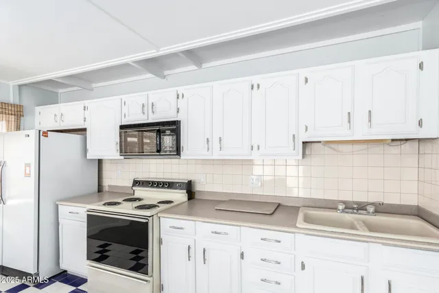 a kitchen with granite countertop white cabinets and white appliances