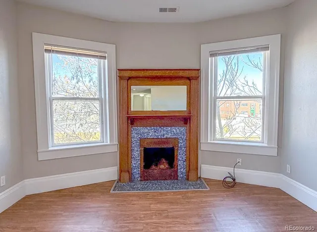 a living room with a fireplace and windows