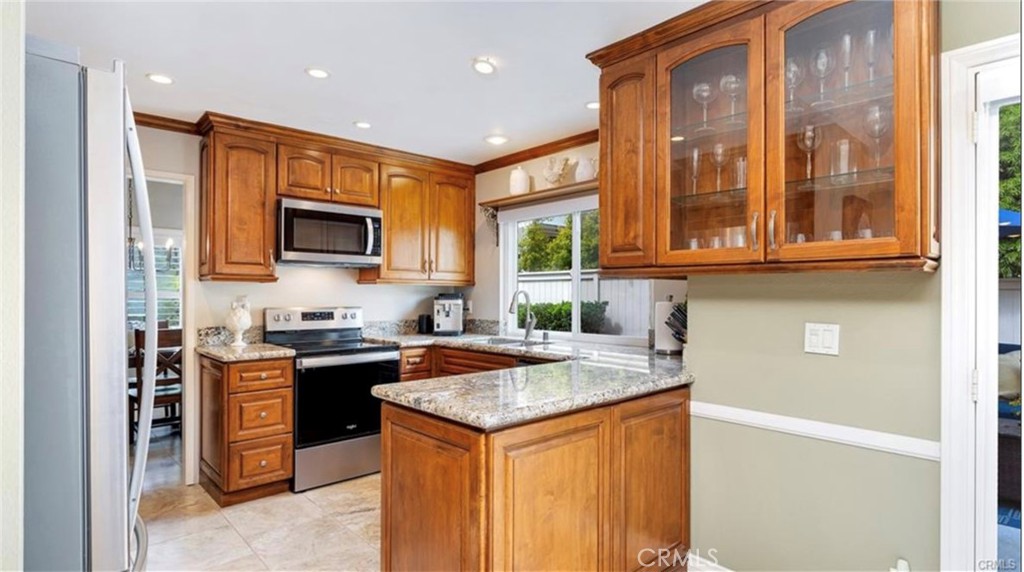 8 Oakgrove, Unit 54 Irvine, CA 92604 - Photo 7 of 14 a kitchen that has a sink a stove top oven a granite counter space and cabinets