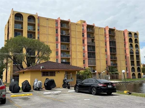 a front view of a building with lot of cars parked