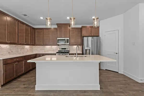 a kitchen with kitchen island a white cabinets and refrigerator