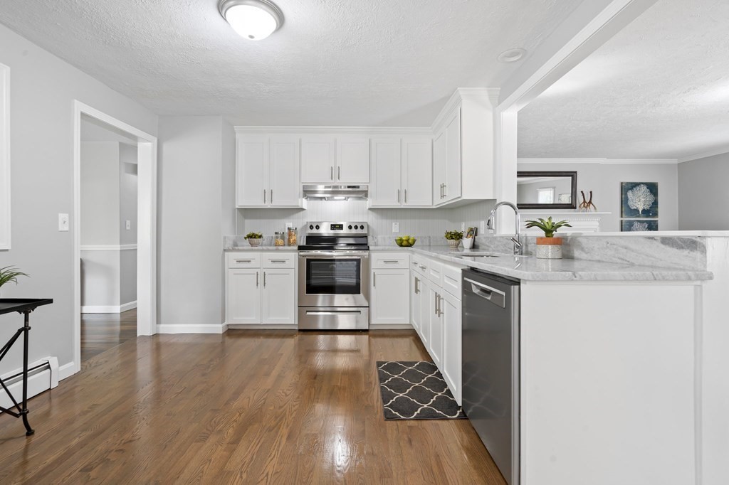 6 Glen Road Peabody, MA 01960 - Photo 7 of 35 a kitchen with stainless steel appliances granite countertop a stove top oven a sink dishwasher and white cabinets with wooden floor