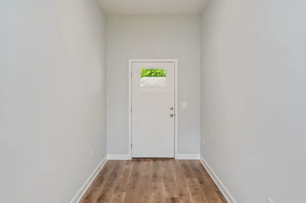 a view of an empty room with closet and a window