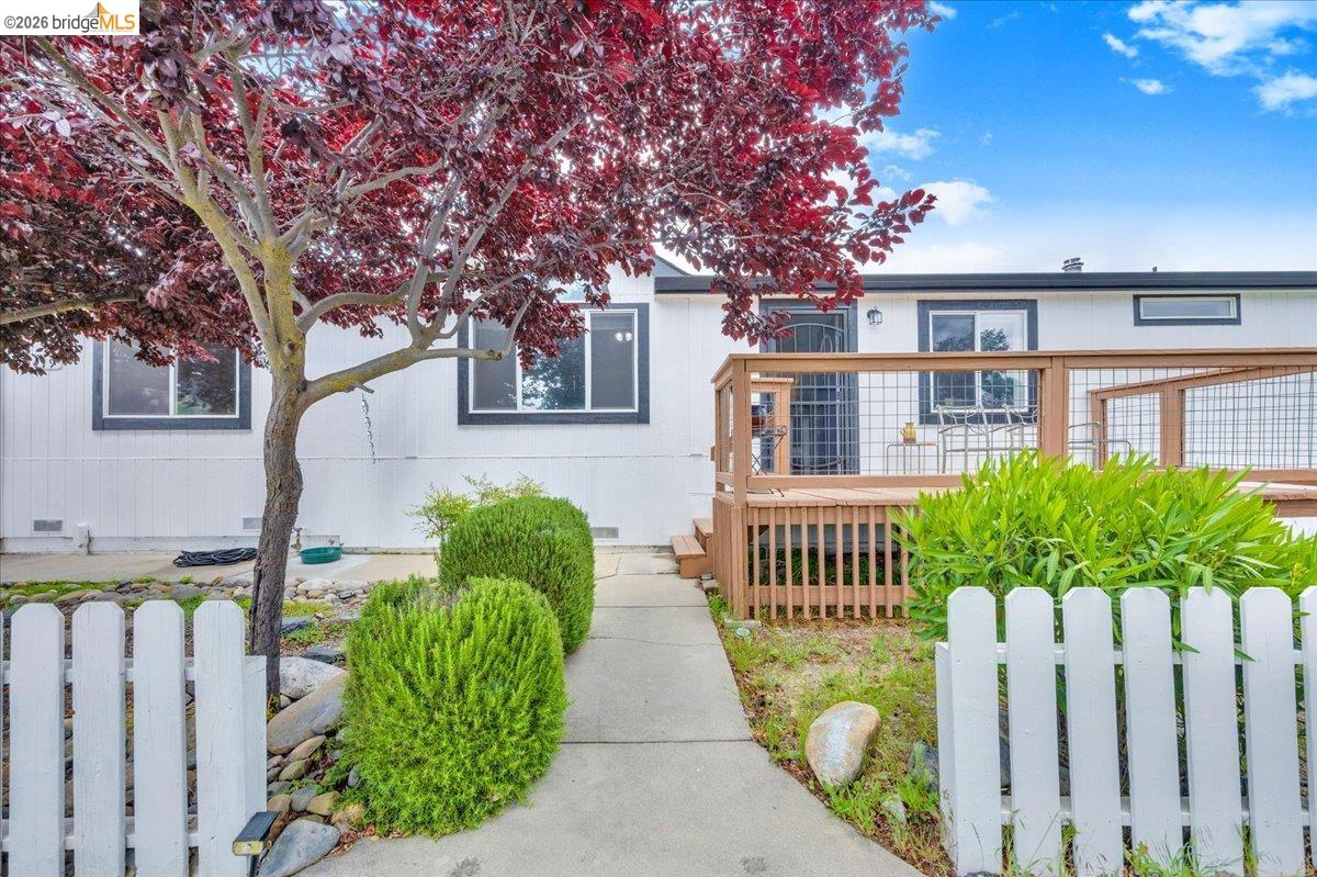 4419 Little John Road Copperopolis, CA 95228 - Photo 40 of 43 Exterior featuring white siding, dark trim windows, and a prominent wood-finish deck with wire railing