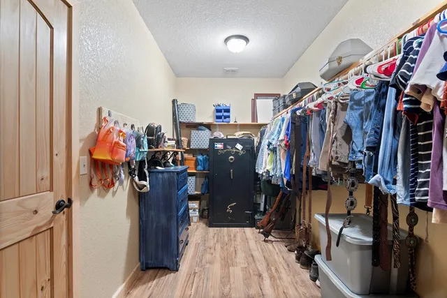 a view of walk in closet with clothes and shoes