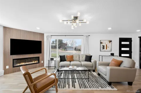 a living room with furniture a flat screen tv and a fireplace
