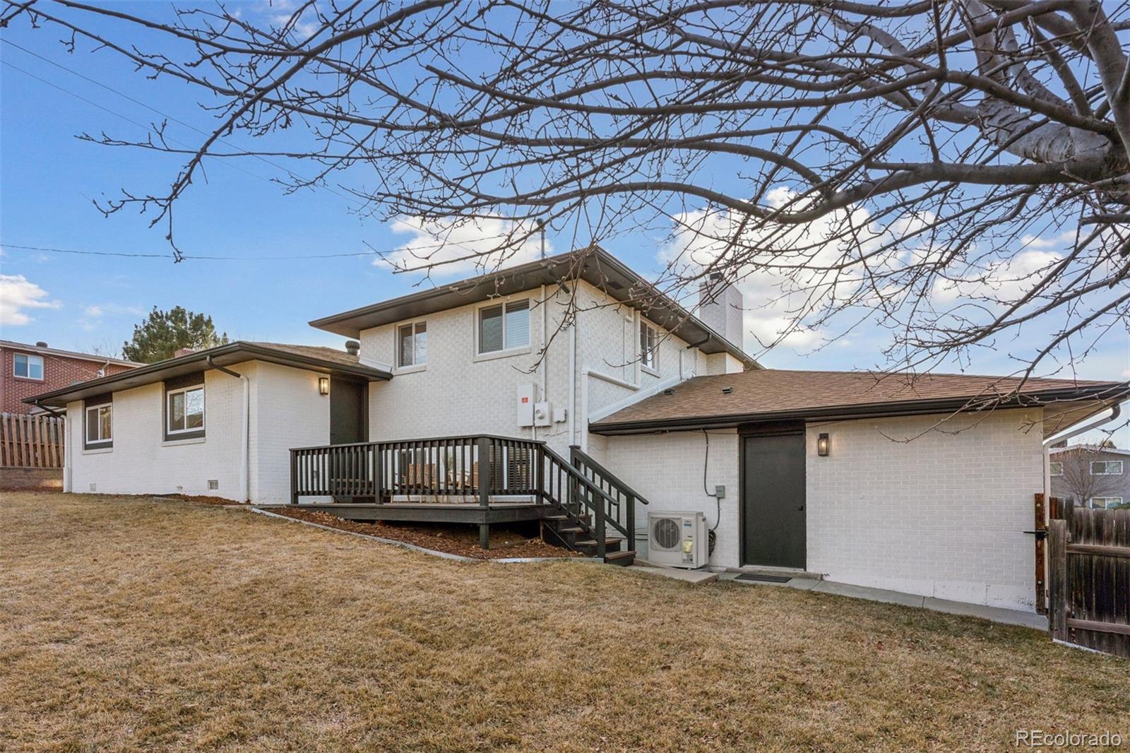 3860 Dudley Street Wheat Ridge, CO 80033 - Photo 32 of 38 a view of a house with a yard and wooden fence