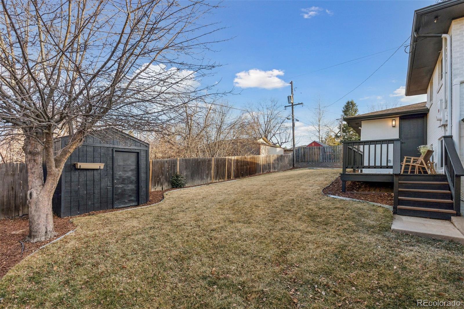 3860 Dudley Street Wheat Ridge, CO 80033 - Photo 33 of 38 a view of a house with a yard and wooden fence