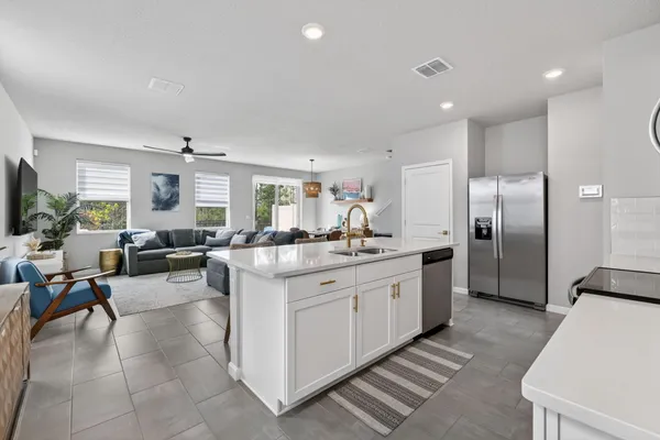 a large kitchen with stainless steel appliances granite countertop a sink and dishwasher a stove top oven with wooden floor