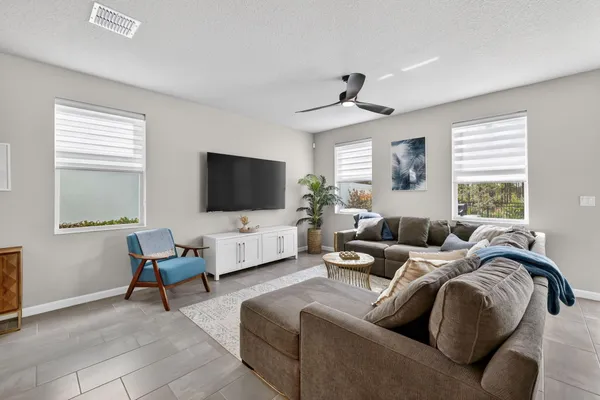 a living room with furniture kitchen view and a window