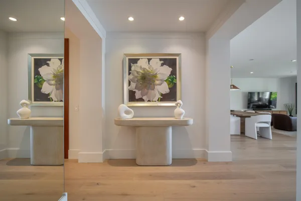 a view of a hallway with wooden floor and furniture