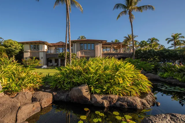 a front view of a house with a yard and swimming pool