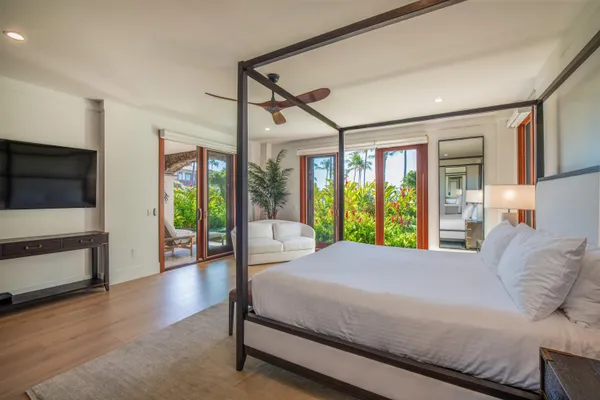 a bedroom with a large bed and a flat tv screen