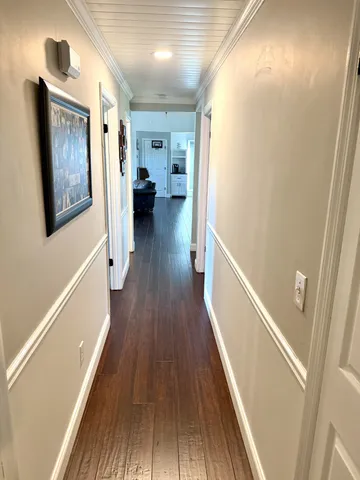 an empty room with wooden floor closet and windows
