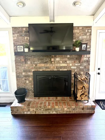 a living room with a fireplace and a flat screen tv