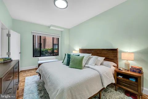 a bedroom with a bed and a large mirror on dresser