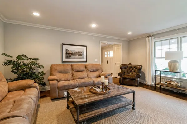 a living room with furniture ceiling fan and a window
