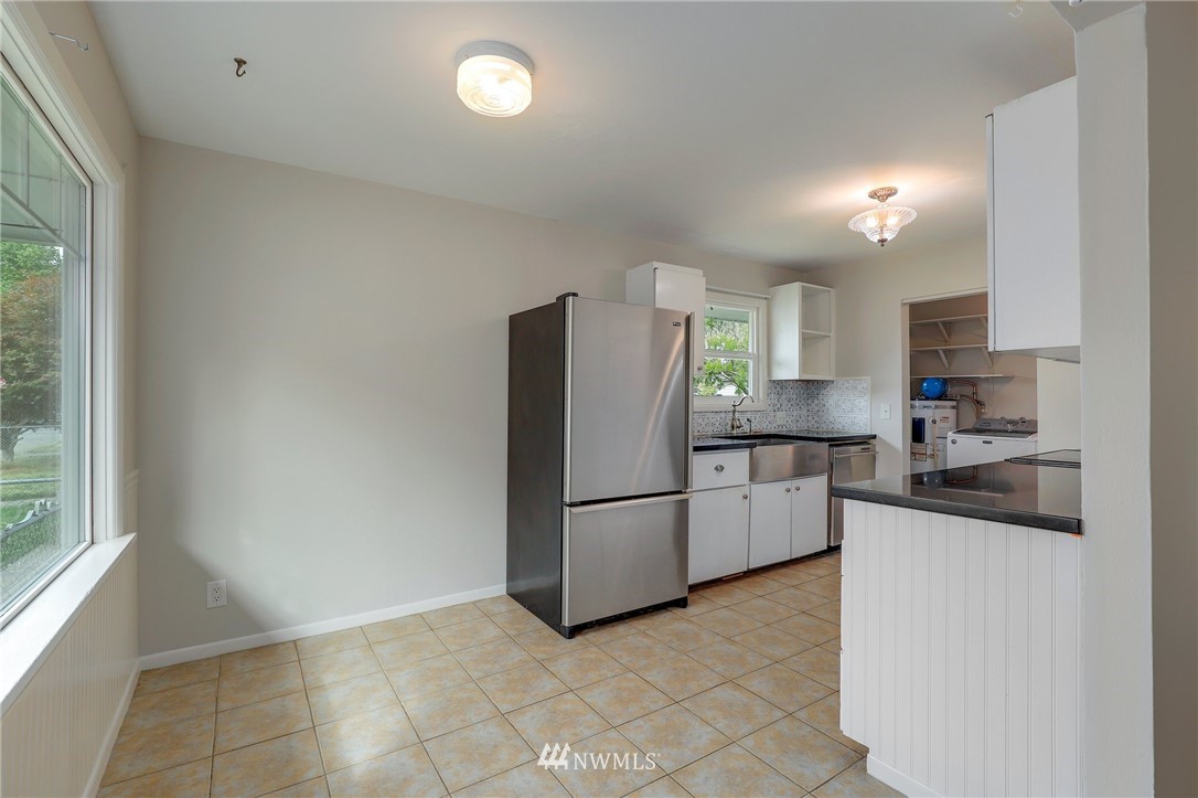 340 Wells Avenue North Renton, WA 98057 - Photo 8 of 23 a kitchen with granite countertop a refrigerator and a stove top oven