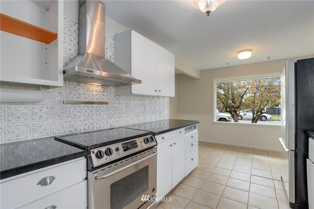 340 Wells Avenue North Renton, WA 98057 - Photo 10 of 23 a kitchen with granite countertop a stove a sink and a counter top space