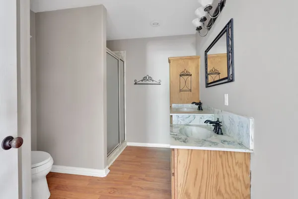 a bathroom with a granite countertop sink toilet and mirror