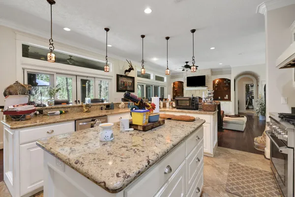 a kitchen with stainless steel appliances granite countertop a sink a stove and a wooden floor
