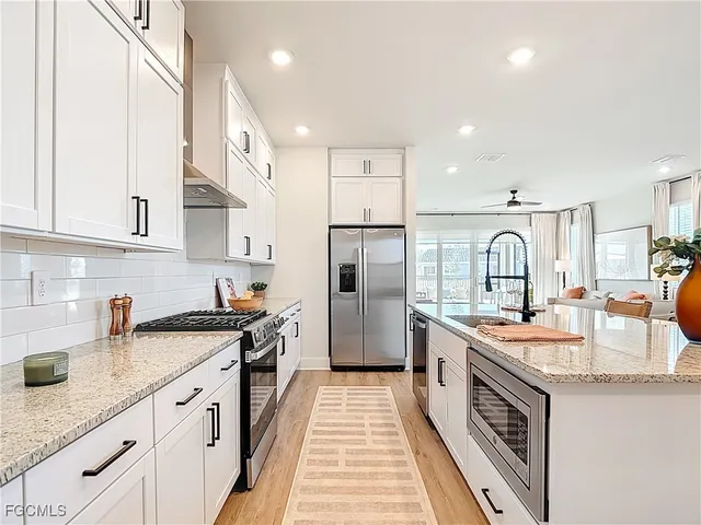 a kitchen with stainless steel appliances granite countertop a sink and cabinets