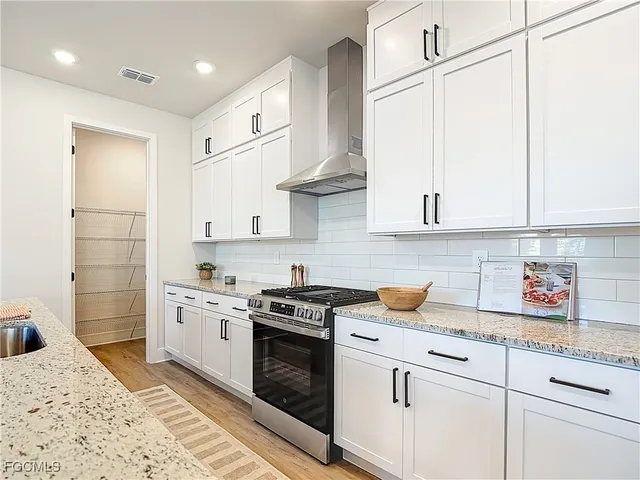 a kitchen with stainless steel appliances granite countertop a sink a stove and a refrigerator