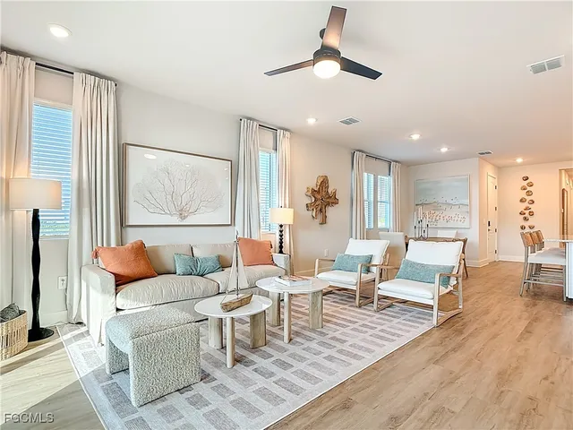 a living room with furniture a ceiling fan and a rug