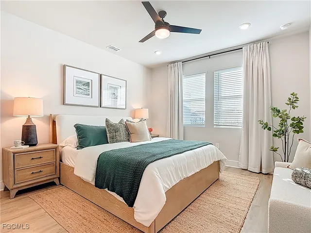 a bedroom with a large bed and a chandelier