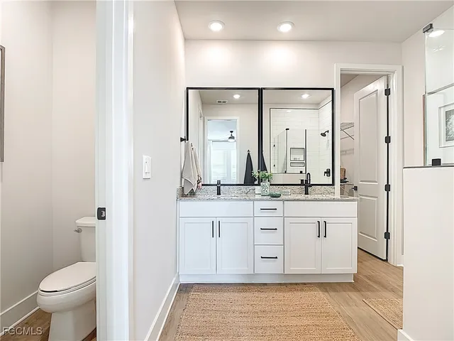 a spacious bathroom with a granite countertop sink mirror and toilet