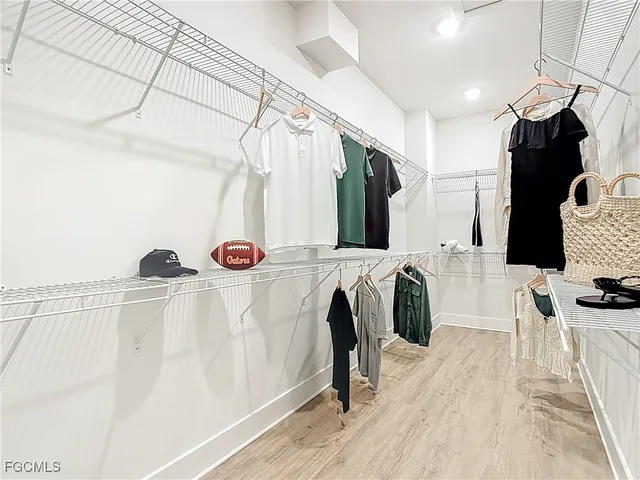 a view of walk in closet with clothes and shoes