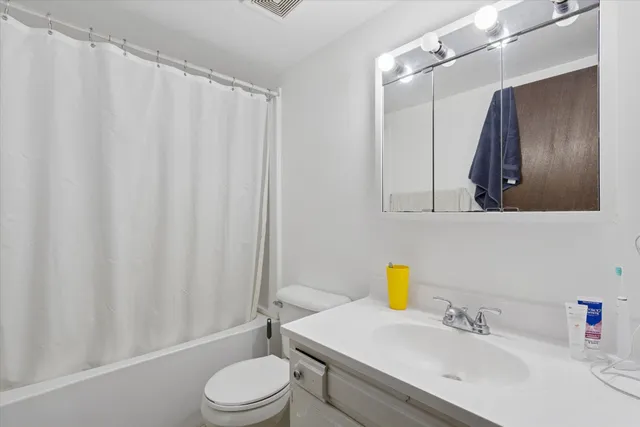 a bathroom with a sink vanity mirror and toilet