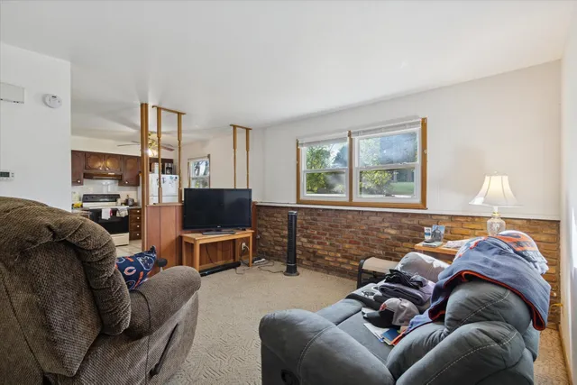 a living room with furniture a flat screen tv and a window